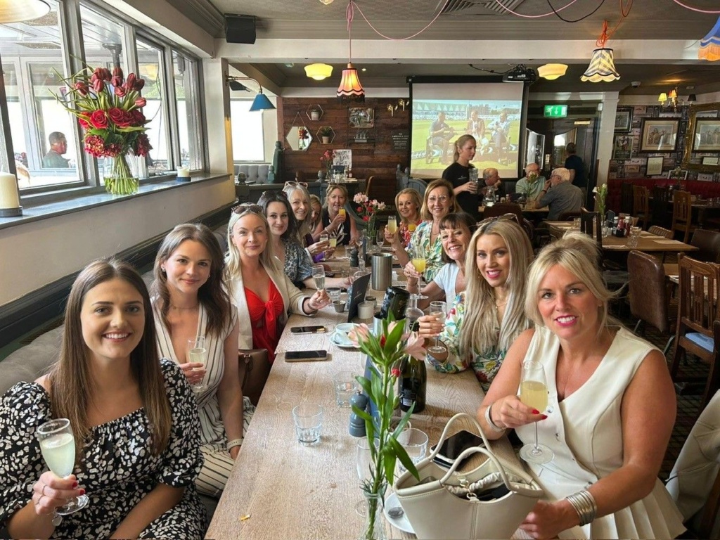 a group of women sitting at a long table
